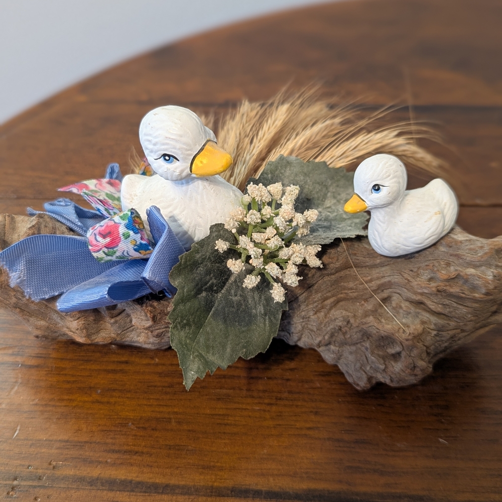 Decorative Duck Figurine Sitting On A Log with Floral Accents And Reeds